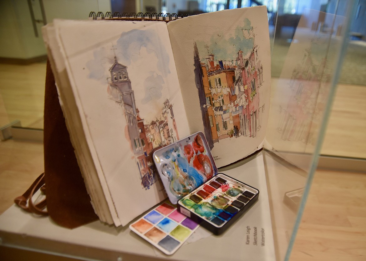 A few of Karen Leigh’s watercolor sketchbooks are part of the art exhibit to honor her career as an educator at the Wanda Hollensteiner Art  Gallery at Flathead Valley Community College. For Leigh, her sketchbooks serve as a diary of her life, travels and artwork. (Heidi Desch/Daily Inter Lake)