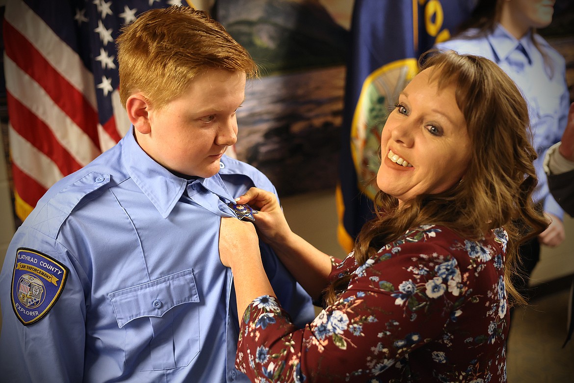 Flathead County Sheriff's Office Explorer Ryder Lake has his badge pinned on by his mother Jamie Lake during a welcoming ceremony Feb. 13. (Jeremy Weber/Daily Inter Lake)