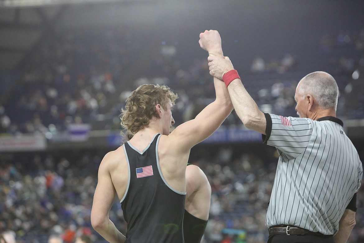 Othello senior Forrest Roylance, left, has his arm raised after defeating Woodland senior Mason Rickard in round two of the 2A 138-pound consolation bracket. Roylance placed 4th in his bracket at the Mat Classic.