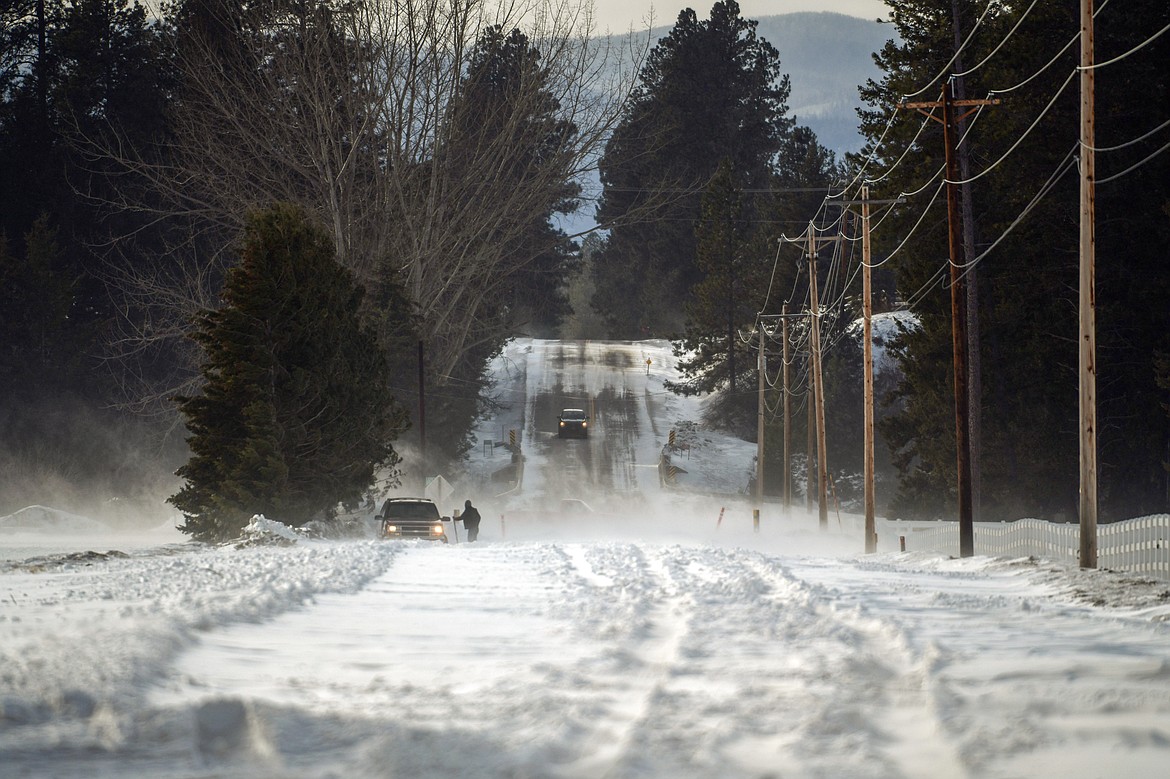 A motorist tries to shovel out a vehicle stuck in snow along Hodgson Road after whiteout conditions caused Flathead County to close the stretch of road between Trumble Creek Road and the Whitefish River on Tuesday, Feb. 21. (Casey Kreider/Daily Inter Lake)