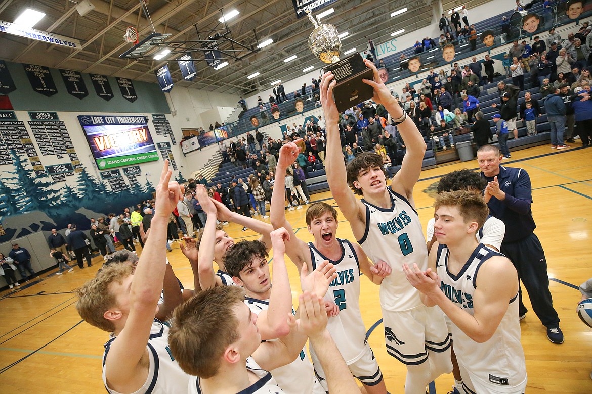 JASON DUCHOW PHOTOGRAPHY
Senior Blake Buchanan (0) holds the trophy aloft after the Lake City Timberwolves won the 5A Region 1 boys basketball championship Tuesday night at Lake City, beating the Coeur d'Alene Vikings.