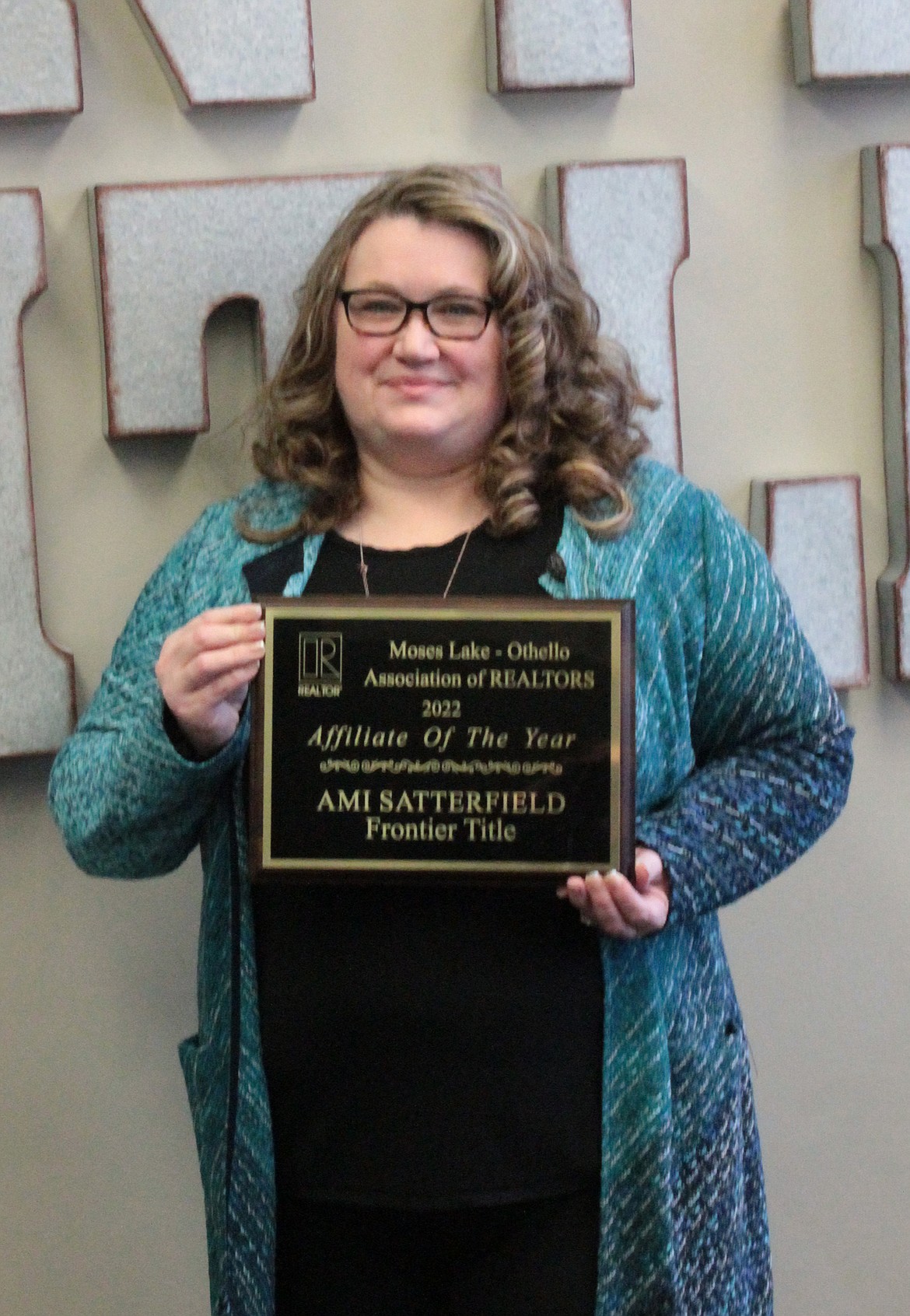 Ami Satterfield shows off her award proclaiming her the Moses Lake-Othello Realtors Association Affiliate of the Year. When she heard she’s been nominated, she said, she thought her teammates were putting her on.