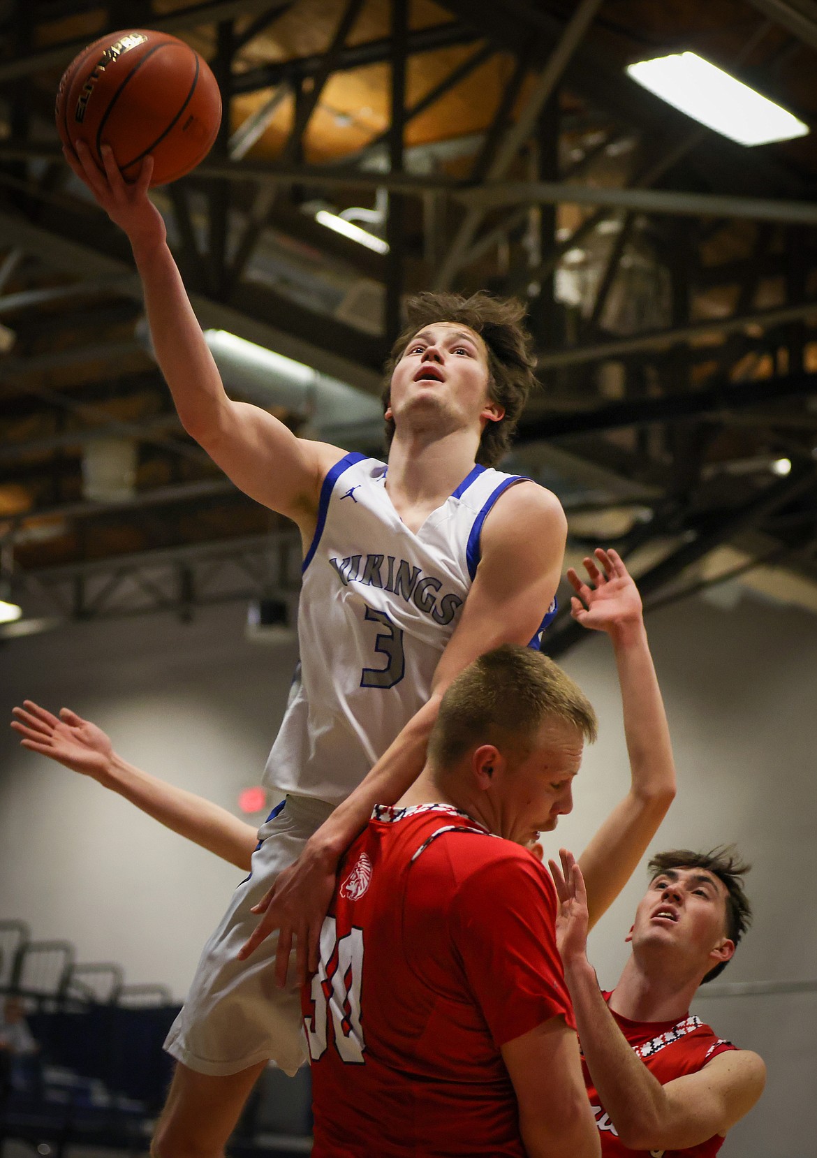 Bigfork’s Isak Epperly rises above Arlee’s Jake Knoll for a basket in the Vikings’ 71-58 win over the Warriors in the first round of the Western B Divisional Tournament in Anaconda on Thursday, Feb. 23. (Jeremy Weber/Daily Inter Lake)