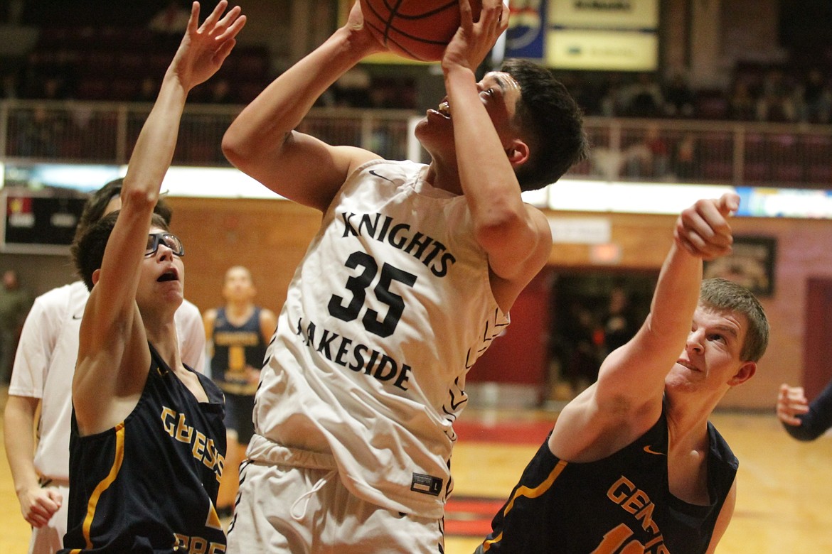 MARK NELKE/Press
Tyson Charley (35) of Lakeside goes up for a shot between two Genesis Prep defenders in the championship game of the 1A Division I District 1 tournament on Thursday night at North Idaho College.