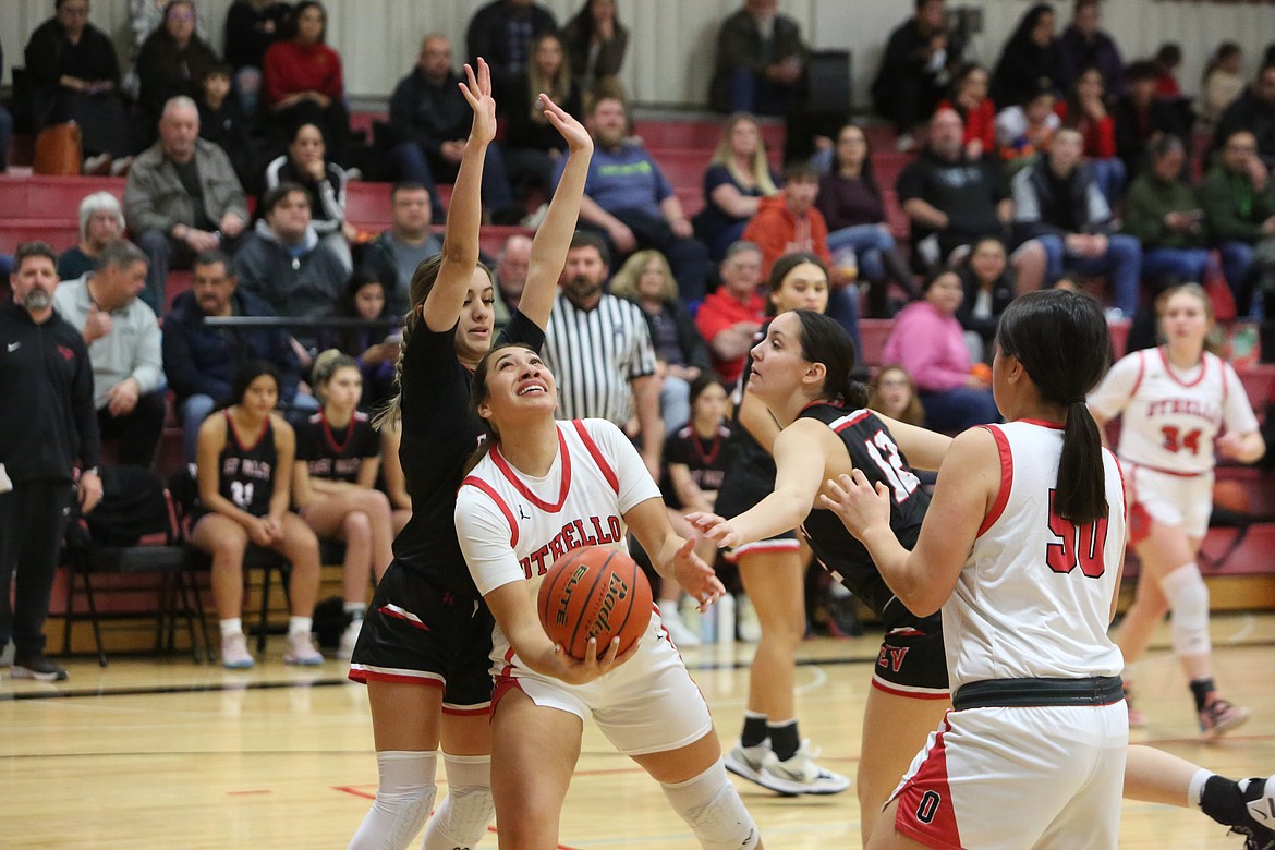 Othello senior Briana Andrade, center, powers past an East Valley (Yakima) defender to shoot a layup against the Red Devils.