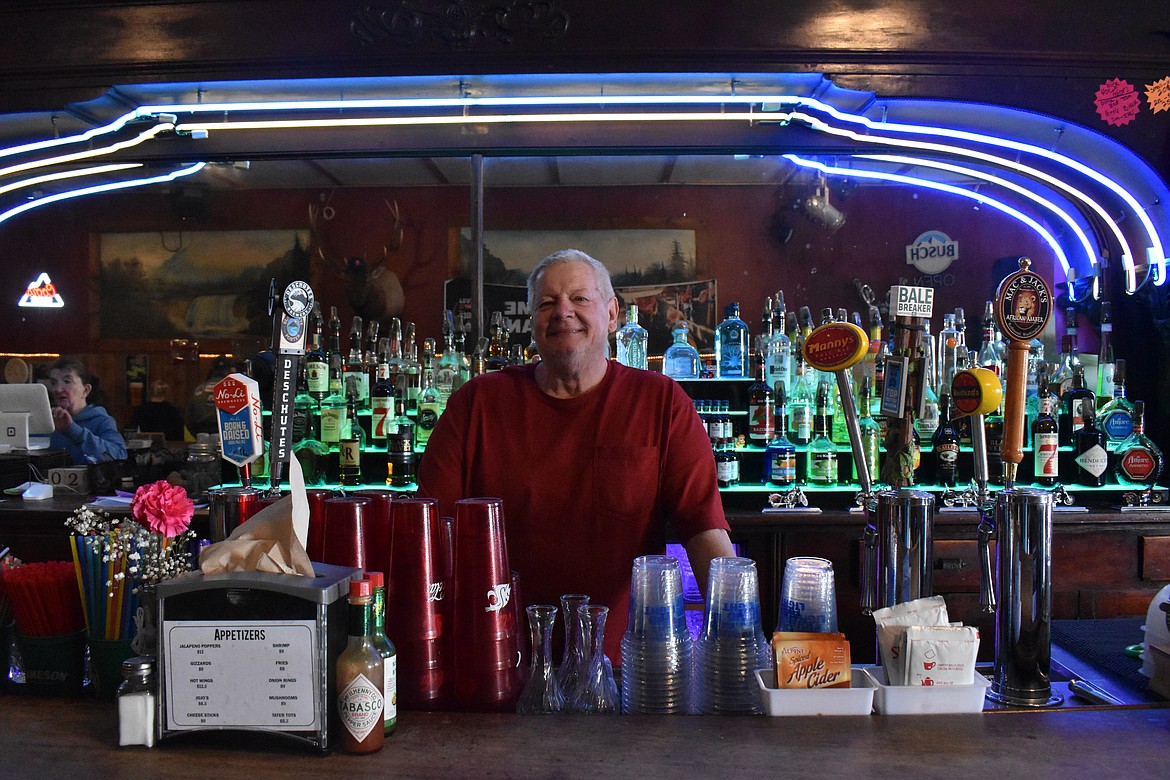 Tom Hattamer, owner of Couleegan’s Bar and Grill, stands in between the over 100 year old barback and bar.