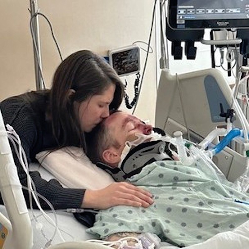 Kate Johnson comforts her husband, Lewis, at Logan Health. (Photo courtesy Montana Highway Patrol)