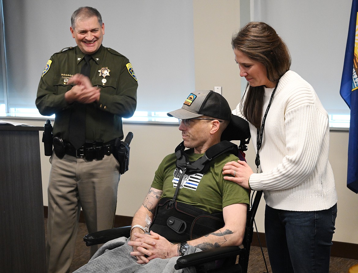 Montana Highway Patrol Trooper Lewis Johnson, his wife and fellow Trooper Kate  Johnson, address a crowd of law enforcement, community members and medical staff during a rally for Lewis Johnson Sunday, Feb. 26, at Logan Health Hospital in Kalispell. To the left is Col. Steve Lavin of the Montana Highway Patrol.(Chris Peterson/Hungry Horse News)