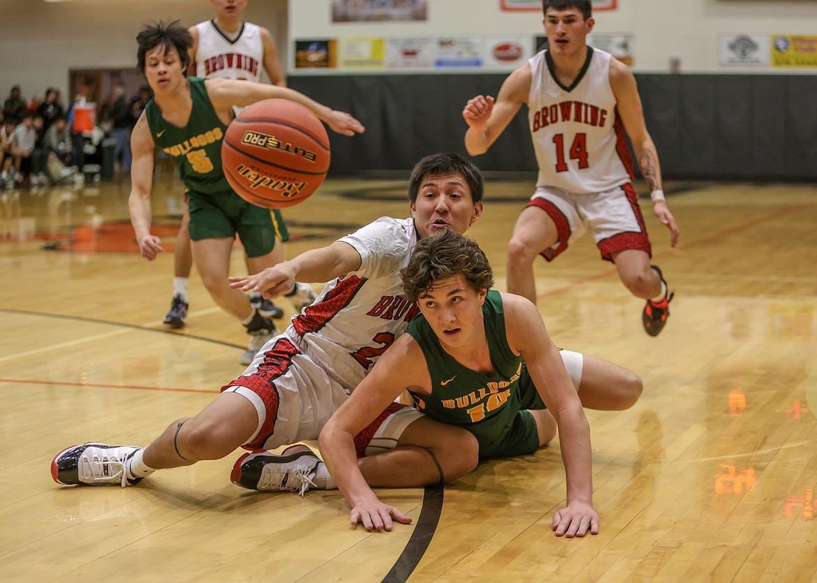 Junior Mason Kelch fights for a loose ball on Friday against Browning in the Western A Divisional Tournament in  Ronan. (JP Edge photo)