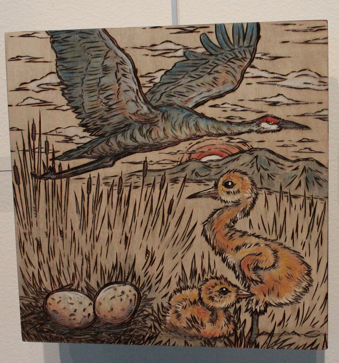 This piece by Ana Li Gresham, showing the life cycle of a sandhill crane, was done by combining wood burning with acrylic paint for vivid color.