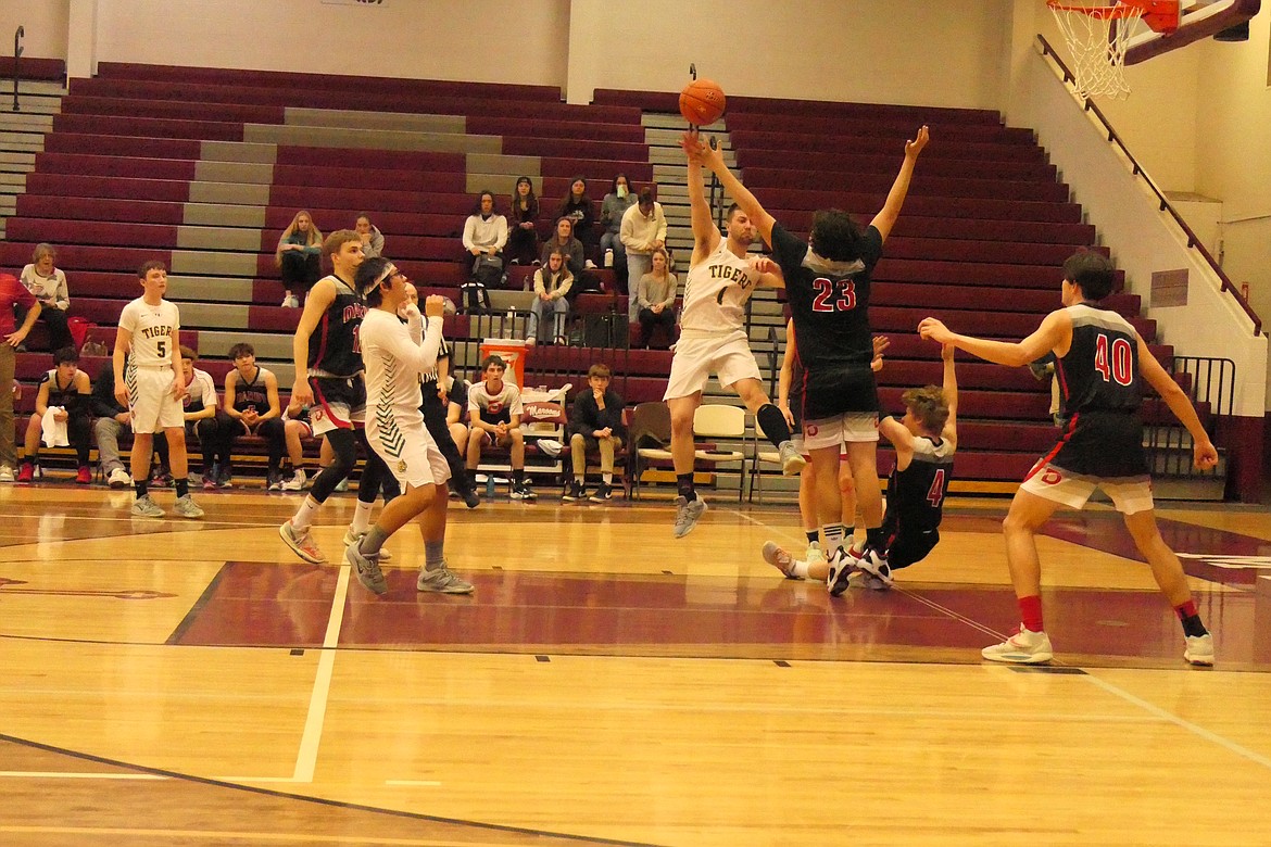 St. Regis senior Caleb Ball shoots over the outstretched arms of Darby's Hooper Reed (23) while teammates Will Martin (40) and Carden Nelson (sitting) look on. (Chuck Bandel/MI-VP)