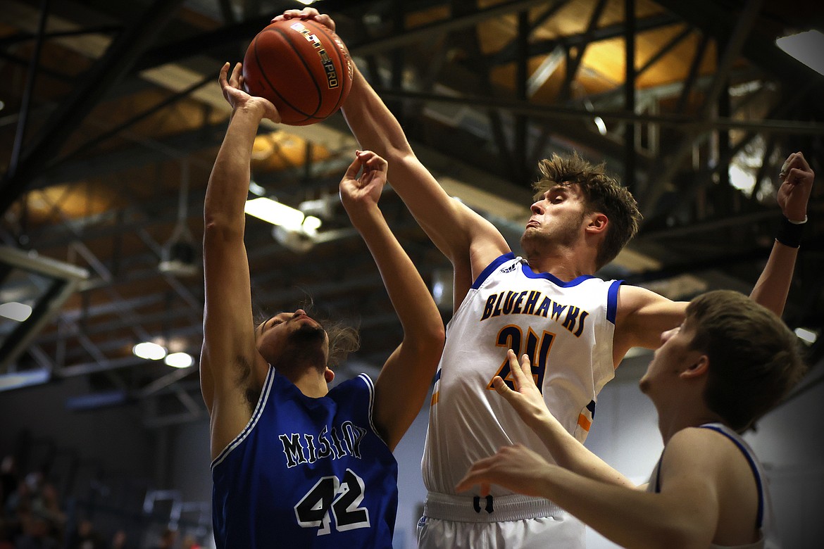 Thompson Falls forward Jesse Claridge blocks the shot of Mission's Erich Morigeau during action at the Western B Divisional Tournament in Anaconda over the weekend. (Jeremy Weber/Bigfork Eagle)