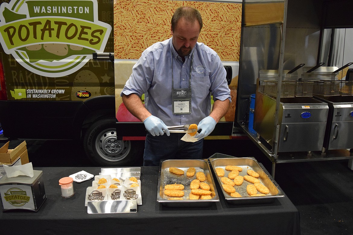 Grant Morris, a potato farmer in Pasco and a commissioner overseeing the Washington Potato Commission, serves up hot hash brown patties on the floor of the Toyota Arena during the 2023 Washington-Oregon Potato Conference.