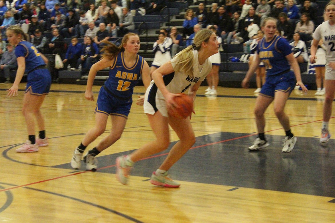 Warden’s Lauryn Madsen (0) beats Adna’s Natalie Loose (12) on her way to the basket in Saturday’s 61-45 Cougar victory in the first game of the WIAA Class B state basketball tournament.