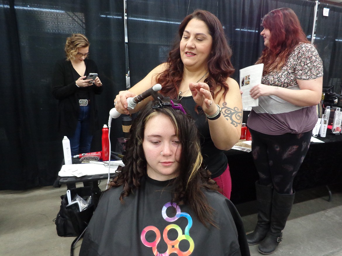 Joelle de Herrera of Ruby Red Designs curls Megan Jones’ hair as part of Jones’ preparation for the bridal gown show.