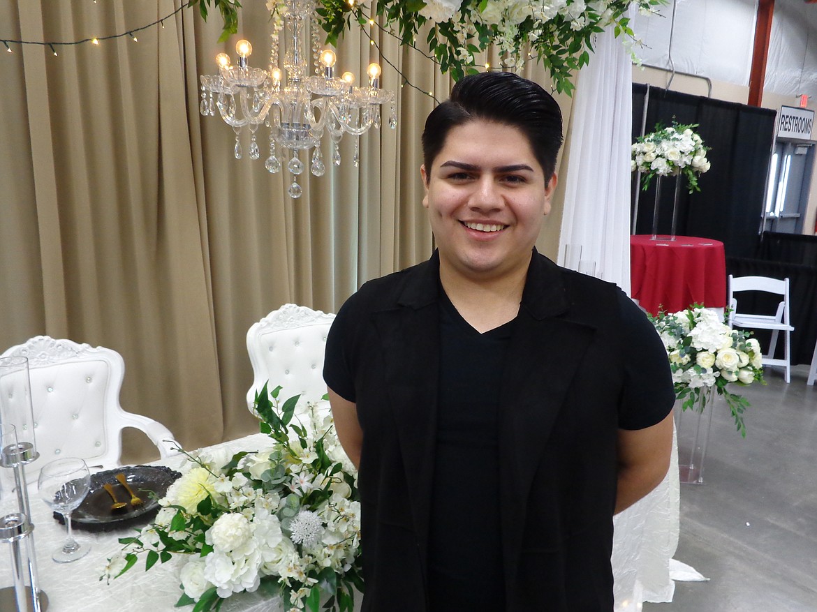 Decorator and designer Guillermo Hermosillo in front of a sample table and room set he designed. Hermosillo said he works a lot of weddings and quinceaneras and enjoys the challenge of turning an ordinary room into a special place for a special event.