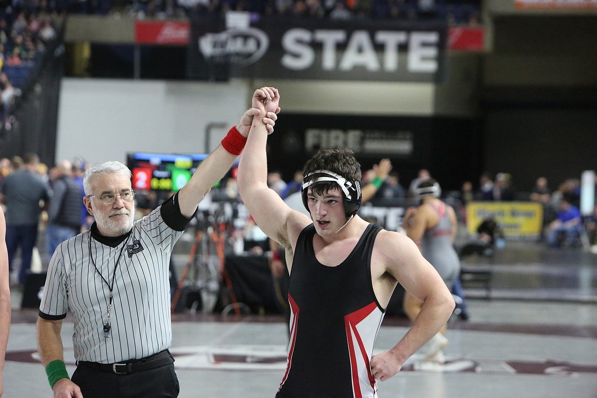 Lind-Ritzville/Sprague junior Gabe Smith, right, has his arm raised in victory at the Mat Classic. Smith took third place in the 2B/1B boys 195-pound bracket.