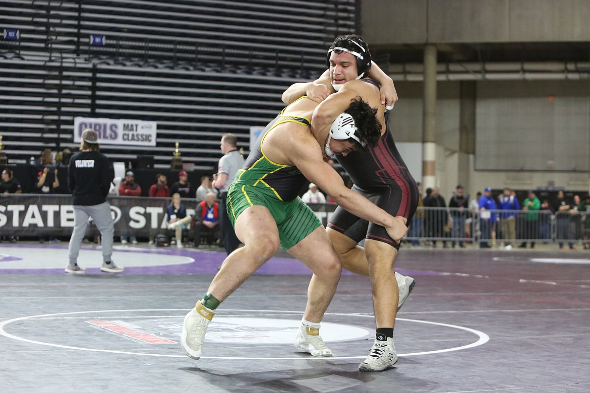 Quincy senior David Medina, left, and Wahluke senior Anthony Zebrano, right, wrestle against each other at the Mat Classic. Medina placed in the 1A 220-pound bracket, and Zebrano placed third.