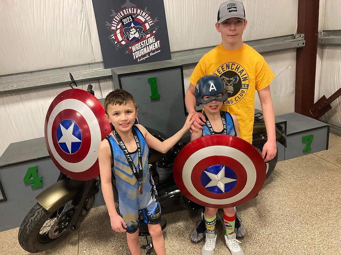 Junior division champion Hunter Rooney (in yellow shirt) joins Cash Katzer and Waylon Katzer at last Saturday's Maverick Bench Memorial Tournament. The trio are members of the Libby Wrestling Club. (Photo courtesy Libby Wrestling Club)