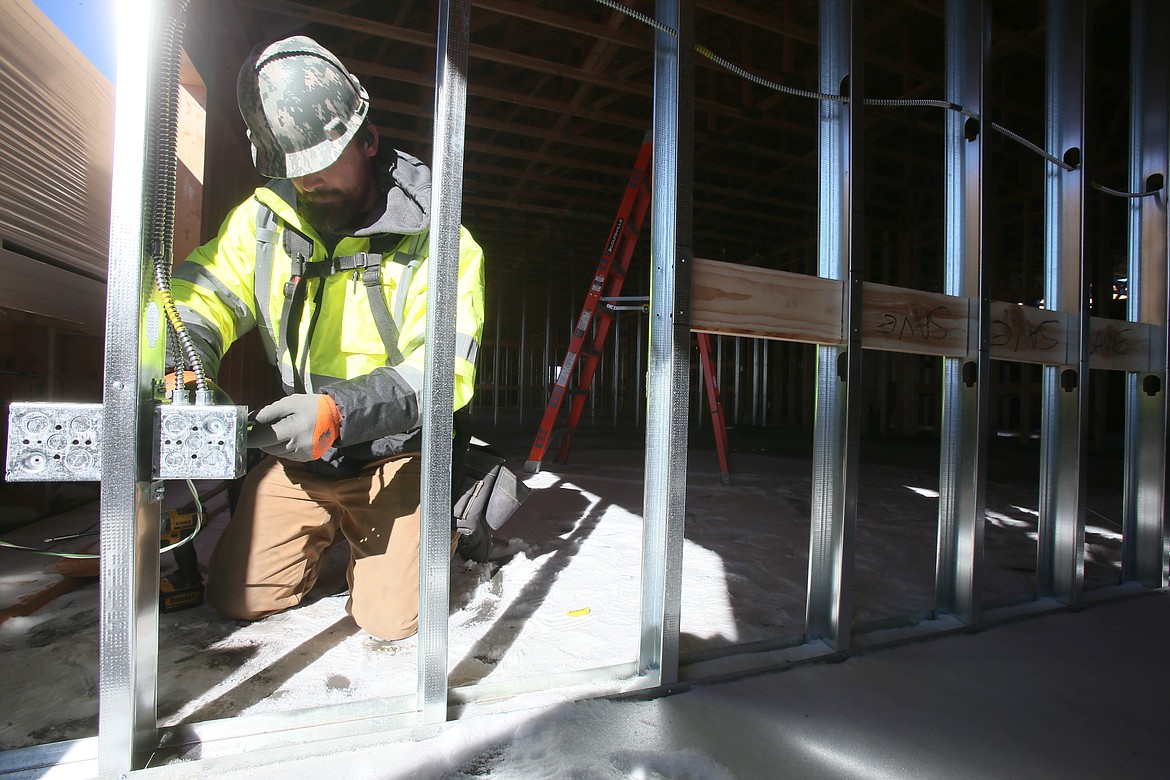 Branden Cutsforth, an electrician with Kaestner Electric Inc., wires an outlet Friday in what will be the main building of Kootenai Classical Academy when it opens this fall in Post Falls.