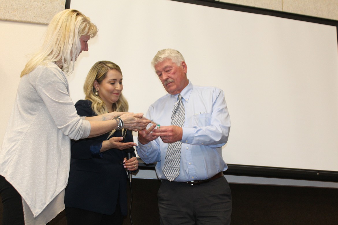 Mike Ruble, right, receives a special award from 2023 Othello Chamber president Heather Miller, left, and 2022 president Thalia Lemus, center, in honor of his late daughter, Othello teacher Mary Jo Harvey, at Friday’s Chamber banquet.