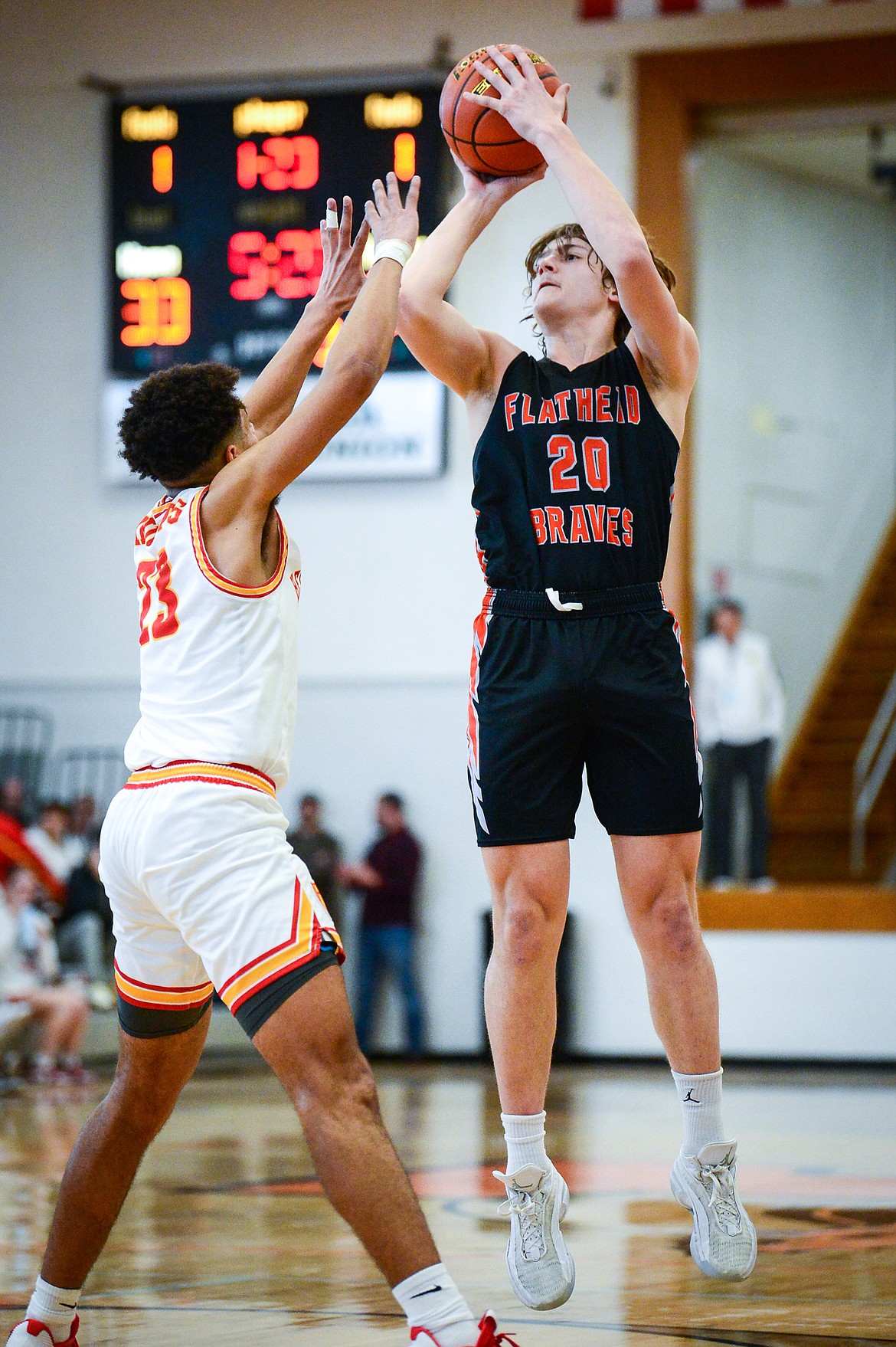 Flathead's Gabe Sims (20) shoots over Missoula Hellgate's Mario Rosemond (23) in the third quarter during the Western AA Divisional Tournament at Flathead High School on Thursday, March 2. (Casey Kreider/Daily Inter Lake)