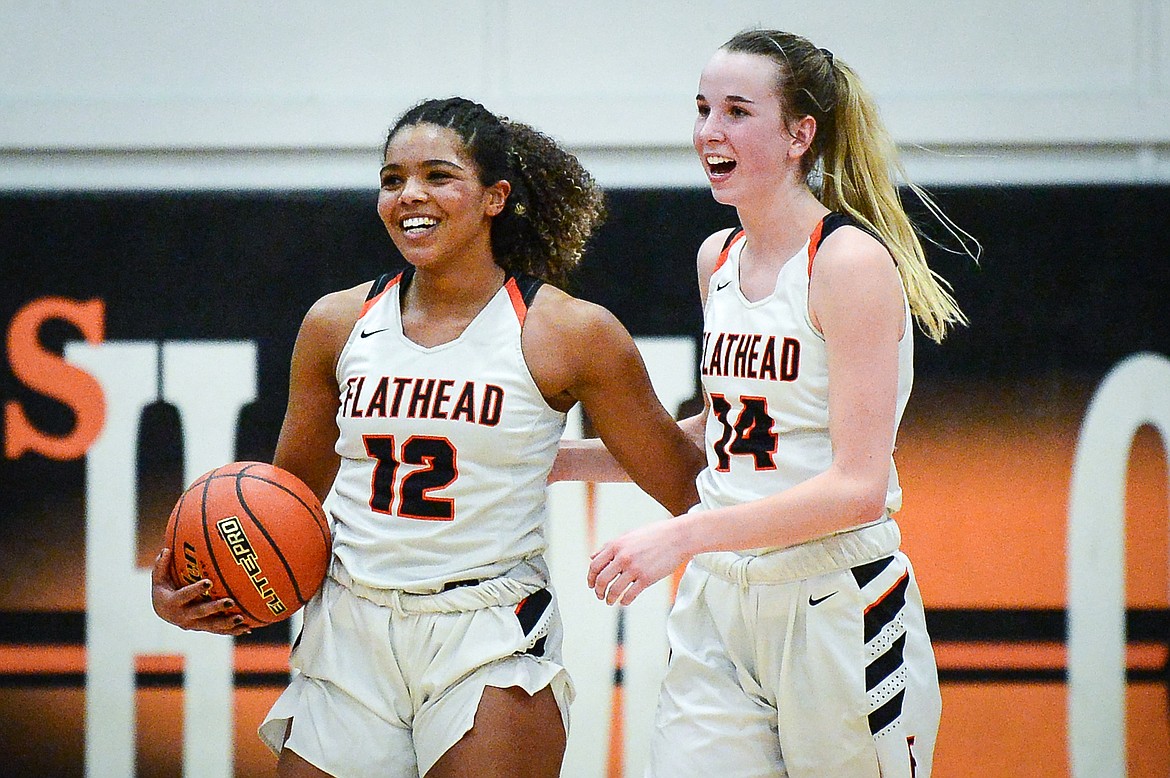 Flathead's Akilah Kubi (12) and Kennedy Moore (14) smile after a win over Butte during the Western AA Divisional Tournament at Flathead High School on Thursday, March 2. (Casey Kreider/Daily Inter Lake)