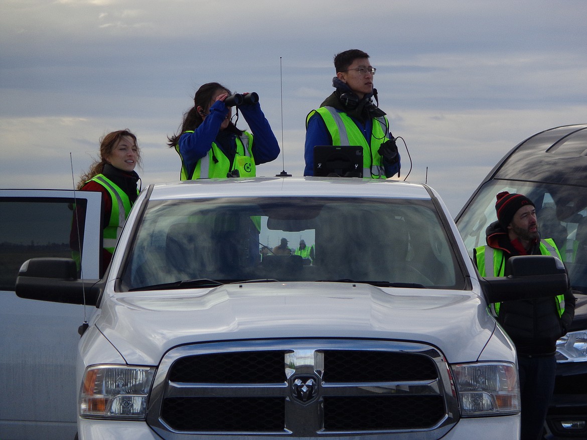 Members of Universal Hydrogen’s flight test team watch as their Dash-8 commuter airliner partially converted to run on a hydrogen fuel cell flies around the Grant County International Airport on Thursday.