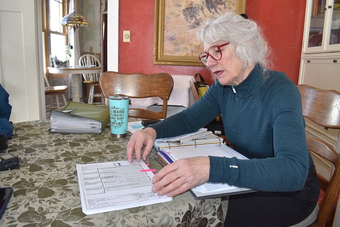 Jennifer Mitchell thumbs through her husband’s medical records from his time at the Montana State Hospital. After Mitchell's husband was discharged from the hospital, she discovered he was taken off some of his congestive heart failure medications. He later suffered cardiac arrest and died in hospice care. (Aaron Bolton/Montana Public Radio)