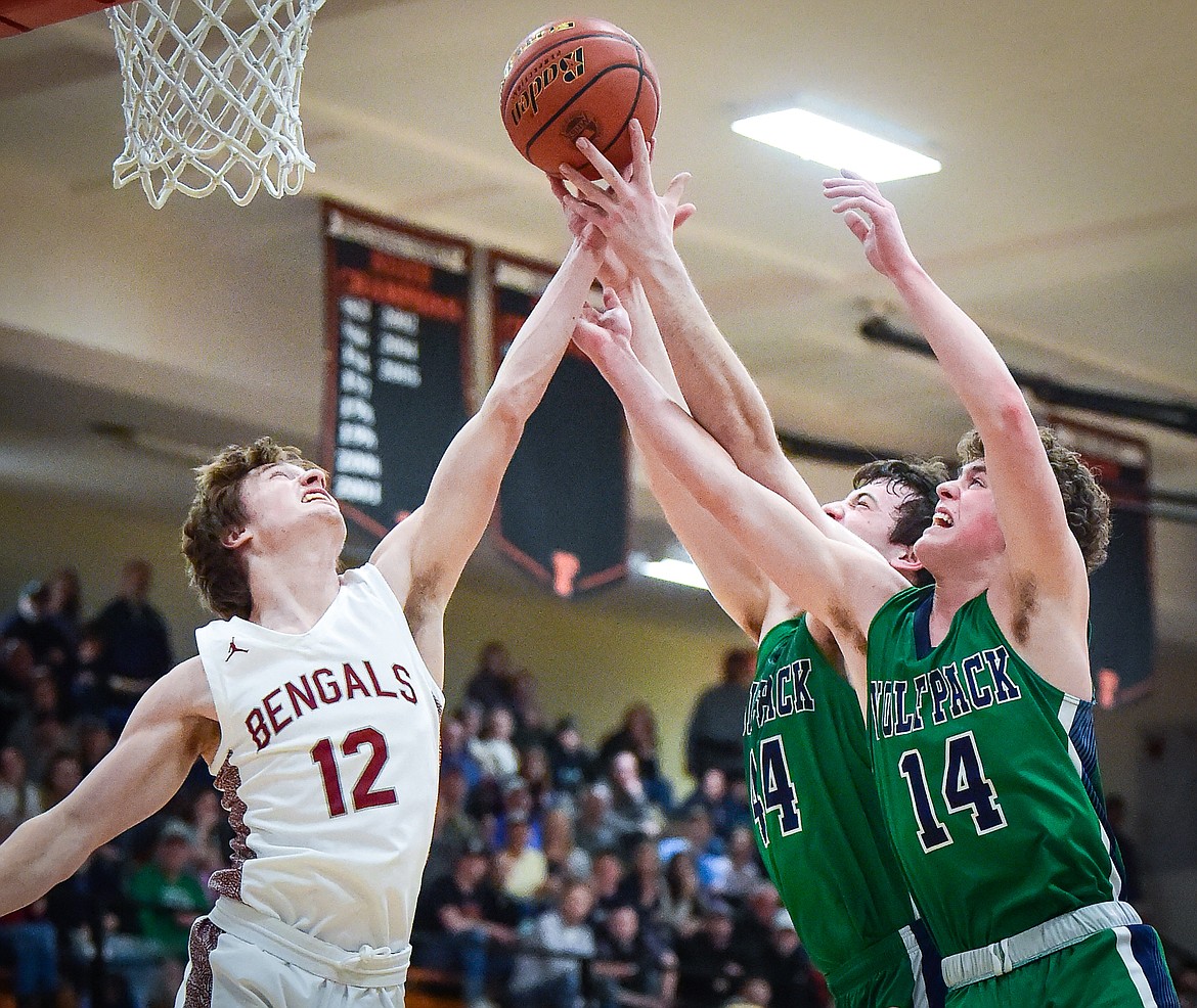 Glacier's Kaidrian Buls (14) and Noah Dowler (44) battle for a rebound with Helena's Dylan Mosness (12) in the first half of the Western AA Divisional Tournament semifinal at Flathead High School on Friday, March 3. (Casey Kreider/Daily Inter Lake)