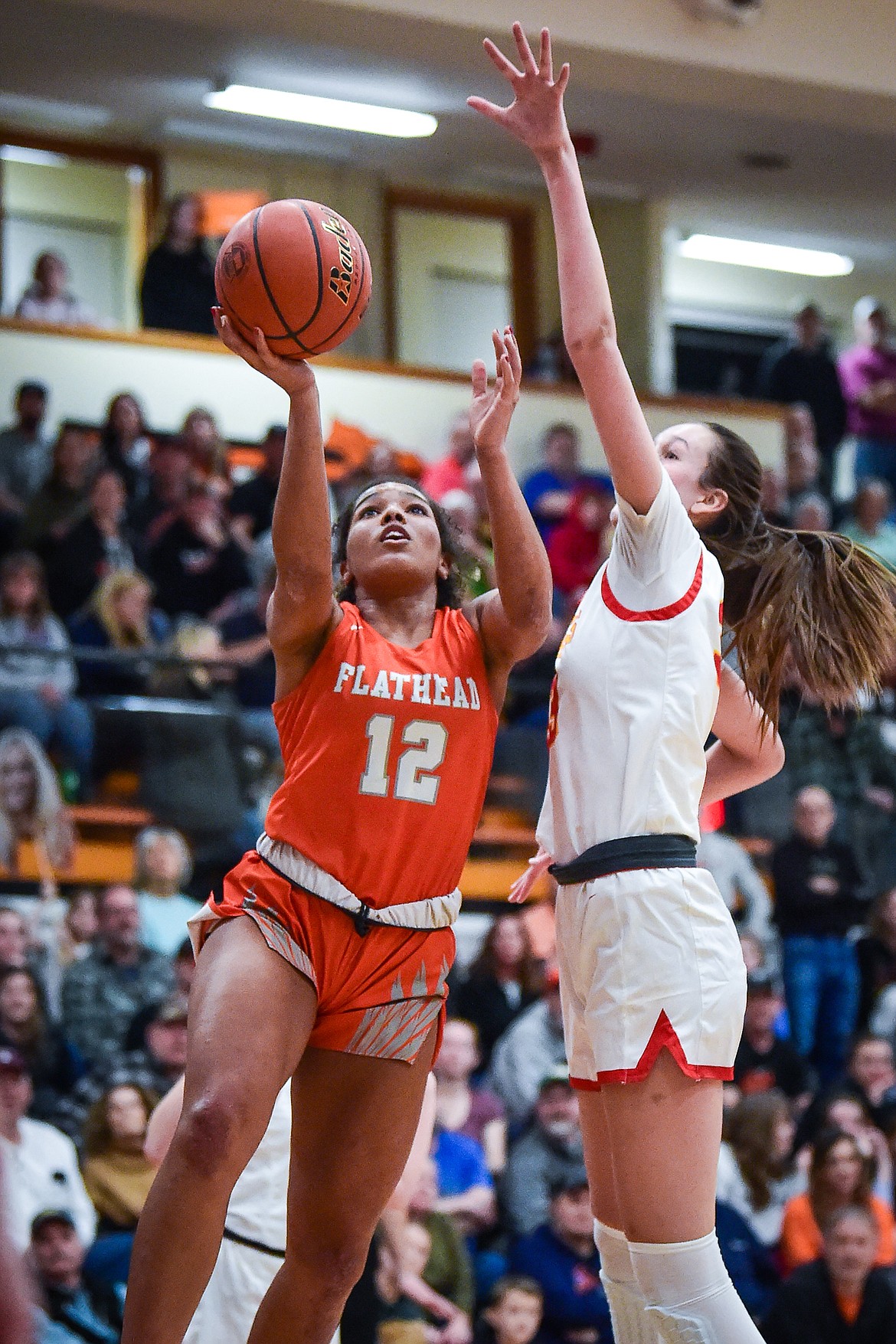 Flathead's Akilah Kubi (12) drives to the basket in the second half against Missoula Hellgate's Alex Covill (33) in the the Western AA Divisional Championship at Flathead High School on Saturday, March 4. (Casey Kreider/Daily Inter Lake)