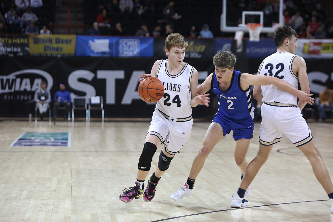 MLCA/CCS freshman James Robertson (24) looks for a lane to the basket after his teammate and fellow freshman Dennis Gulenko (32) sets a screen.