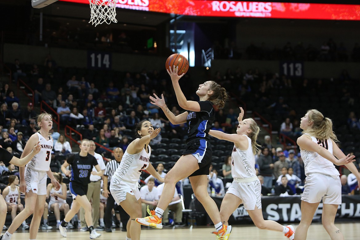 Warden senior Quinn Erdmann races past Napavine defenders for a layup in the second quarter of the Cougars’ 54-47 win over the Tigers.