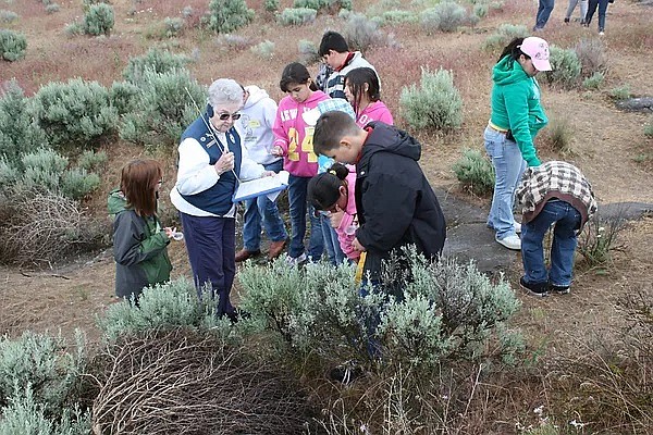 Margaret Schiffner, center, leads a group of elementary school students on a field trip to the Columbia National Wildlife Refuge.