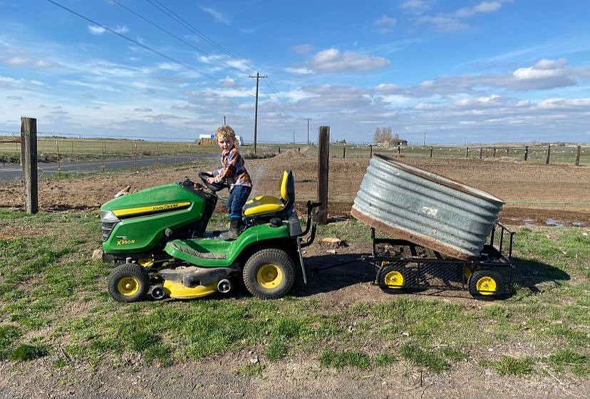 Five-year-old William Parrott helps his mom Valerie with garden cleanup in the spring at their flower farm. Planting season may be a ways off, but there’s still plenty to do to get ready.