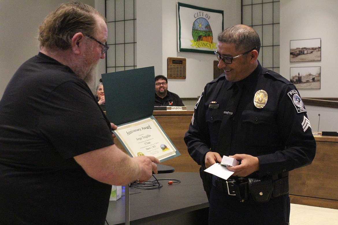 Quincy Mayor Paul Worley, left, presents Quincy Police Department Sergeant Jorge Trujillo with a certificate recognizing his 15 years with the QPD at the Quincy City Council meeting Tuesday.
