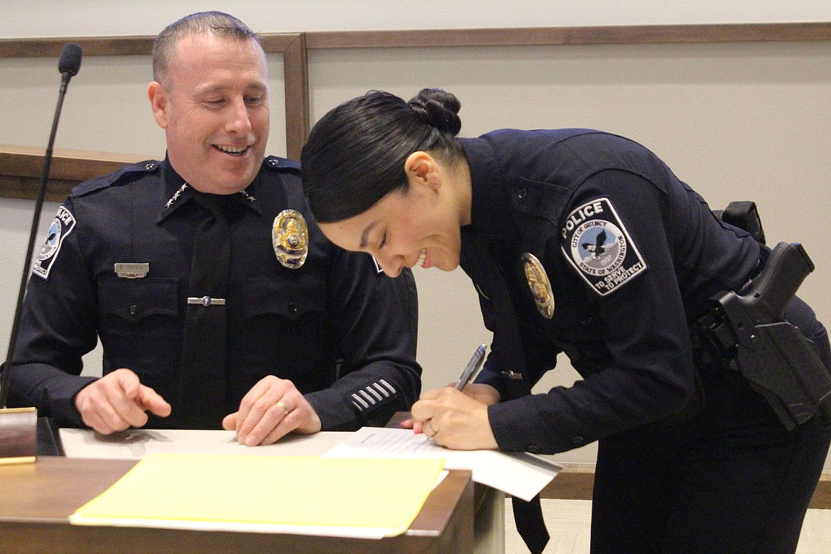 New Quincy Police Department Officer Joanna Navarro signs her oath of office with new QPD Chief Ryan Green Tuesday.