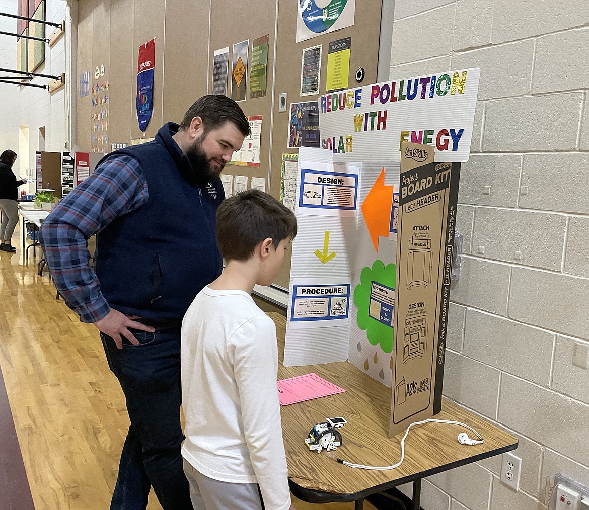 Ramsey Magnet School of Science fourth grader Tyler Sattler on March 2 shows his engineering design to volunteer judge Seth Deniston during the school's annual science fair. More than 20 community volunteers helped judge science and engineering projects created by 230 kindergarten-through-fifth grade students.