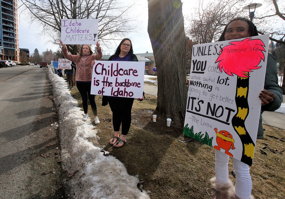 Mersadeis Hawkins, right, Teal Brown, center, and Cherilyn Darrah join a rally for Idaho child care on Front Avenue in Coeur d'Alene on Wednesday.