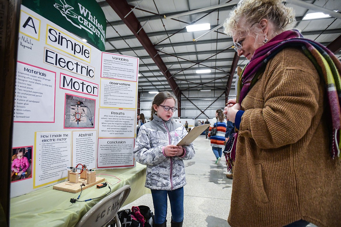 Natalie Raymond, a third-grader at Glacier Gateway Elementary, discusses her project titled "A Simple Electric Motor" to judge Lana Walker at the Flathead County Science Fair at the Flathead County Fairgrounds Expo Building on Thursday, March 9. (Casey Kreider/Daily Inter Lake)