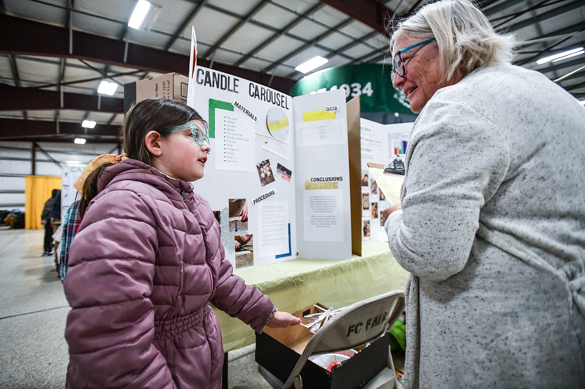 Hadley Gomez, a third-grader at Edgerton Elementary School, discusses her project titled "Candle Carousel" to judge Sue Corrigan at the Flathead County Science Fair at the Flathead County Fairgrounds Expo Building on Thursday, March 9. (Casey Kreider/Daily Inter Lake)
