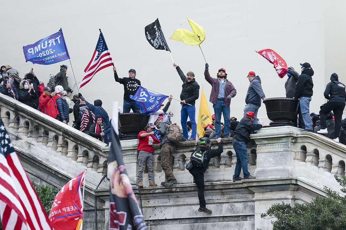 Rioters wave flags on the West Front of the U.S. Capitol in Washington on Jan. 6, 2021. Federal prosecutors are employing an unusual strategy to prove leaders of the far-right Proud Boys extremist group orchestrated a violent plot to keep President Joe Biden out of the White House, even though some of the defendants didn't carry out the violence themselves. AP Photo/Jose Luis Magana, File)