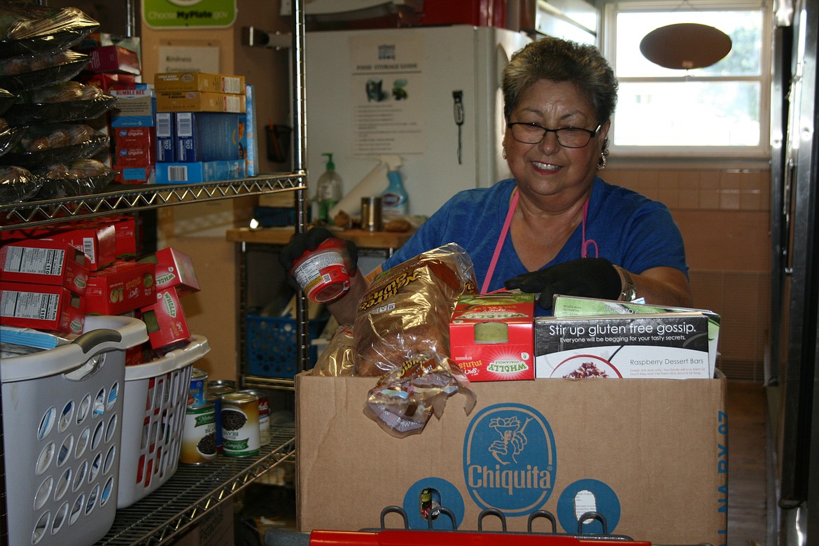 Francis Garcia fills a box at the Othello Food Bank in the summer of 2022. A bill making its way through the Washington State Legislature would allow food banks to spend more money to provide needy families with non-food items like diapers, toiletries and hygiene products.