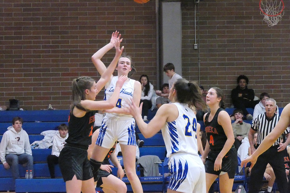 Lady Hawks senior forward Ellie Baxter (white uniform, 4) passes after grabbing a rebound during a game versus Eureka earlier this year.  Baxter was named this past weekend to the Class B All-State team and as a 7B conference first teamer. (Chuck Bandel/VP-MI)