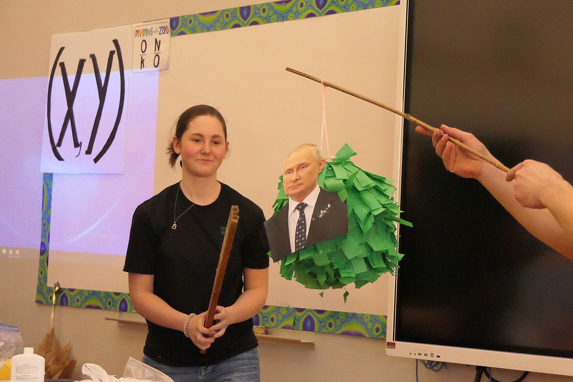 Hannah Warnes takes a swing at a pinata she made featuring a photo of Russian President Vladimir Putin during her "Making a Pinata" presentation at Sunday's 4-H Communications competition at Plains High School. (Chuck Bandel/VP-MI)
