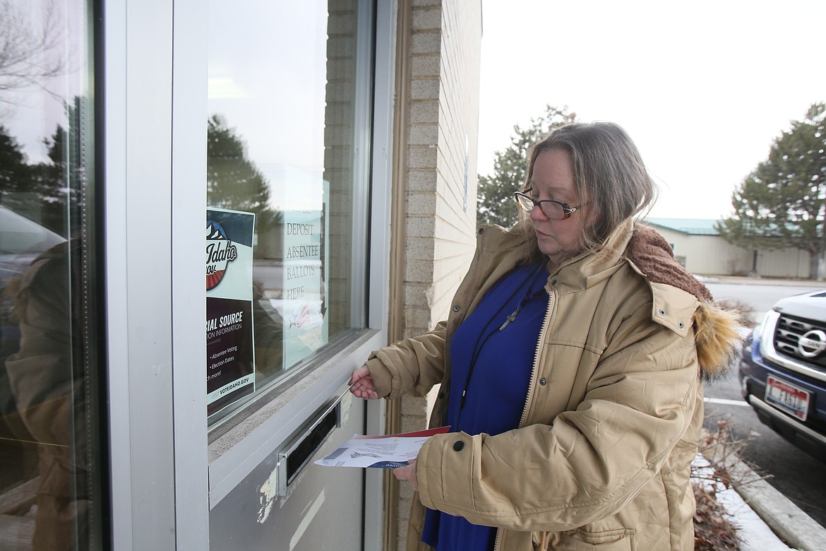 Gayle Mangis, a Coeur d’Alene teacher who lives in Post Falls, drops her absentee ballot into the slot Tuesday at the Kootenai County Elections Office. "Even though my vote goes to Post Falls, I teach in the school district in Coeur d’Alene," she said. “I know how important this is."