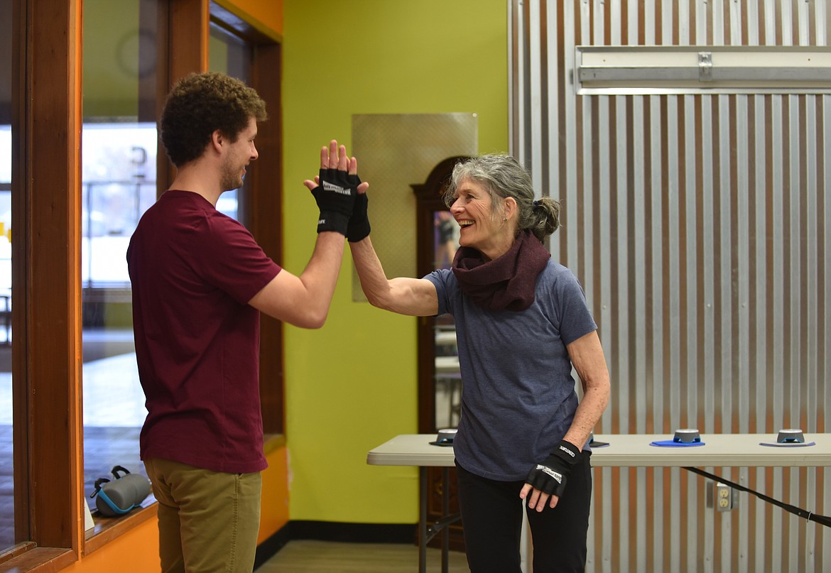 Logan Streit, a Rock Steady Boxing assistant coach and physical therapist at Advanced Rehabilitation Services, high-fives Vicki Byrd, after she finishes a fitness drill during a Monday, March, 13, 2023, class at Gateway Community Center in Kalispell. The no-contact boxing-based fitness program helps people with Parkinson's work on eye-hand coordination, movement. (Hilary Matheson/Daily Inter Lake)