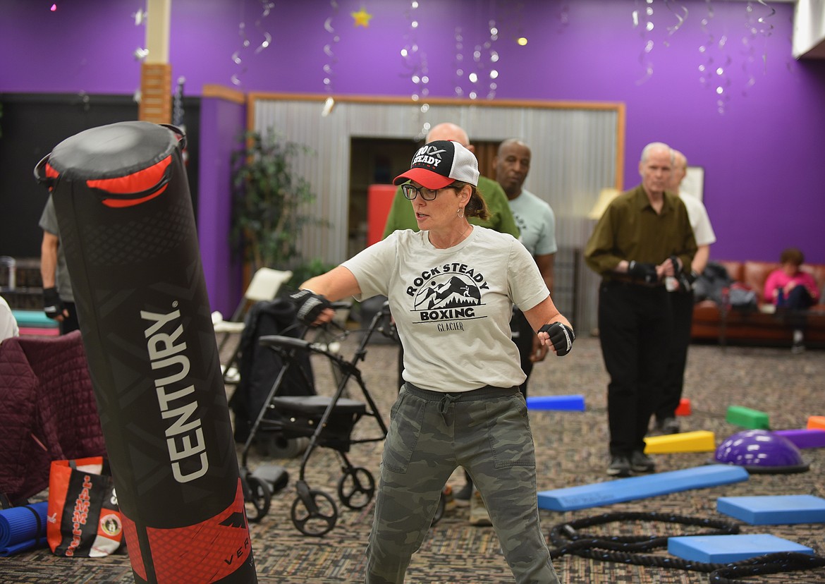 Rock Steady Boxing — Glacier head coach Lynnell Gravelle demonstrates different exercises to participants during a Monday, March, 13, 2023, class at Gateway Community Center in Kalispell. Gravelle, a longtime physical therapist at Advanced Rehabilitation Services, started the affiliate program in the valley in 2018. The no-contact boxing-based fitness program helps people with Parkinson's disease work on eye-hand coordination and movement. (Hilary Matheson/Daily Inter Lake)