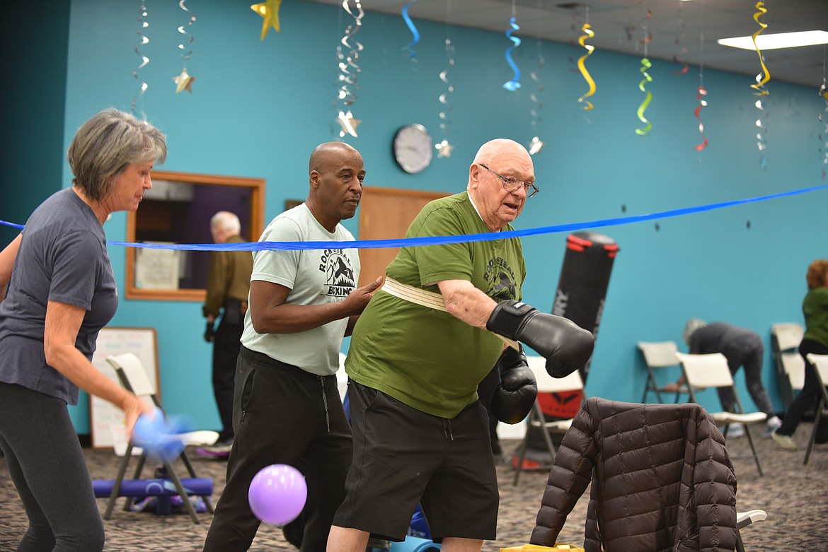 Volunteer Ron Wilton, left, helps participant Duane Morast remain stable during a Rock Steady Boxing class on Monday, March 13, 2023, at Gateway Community Center in Kalispell. The no-contact boxing-based fitness program helps people with Parkinson's disease work on eye-hand coordination and movement. (Hilary Matheson/Daily Inter Lake)