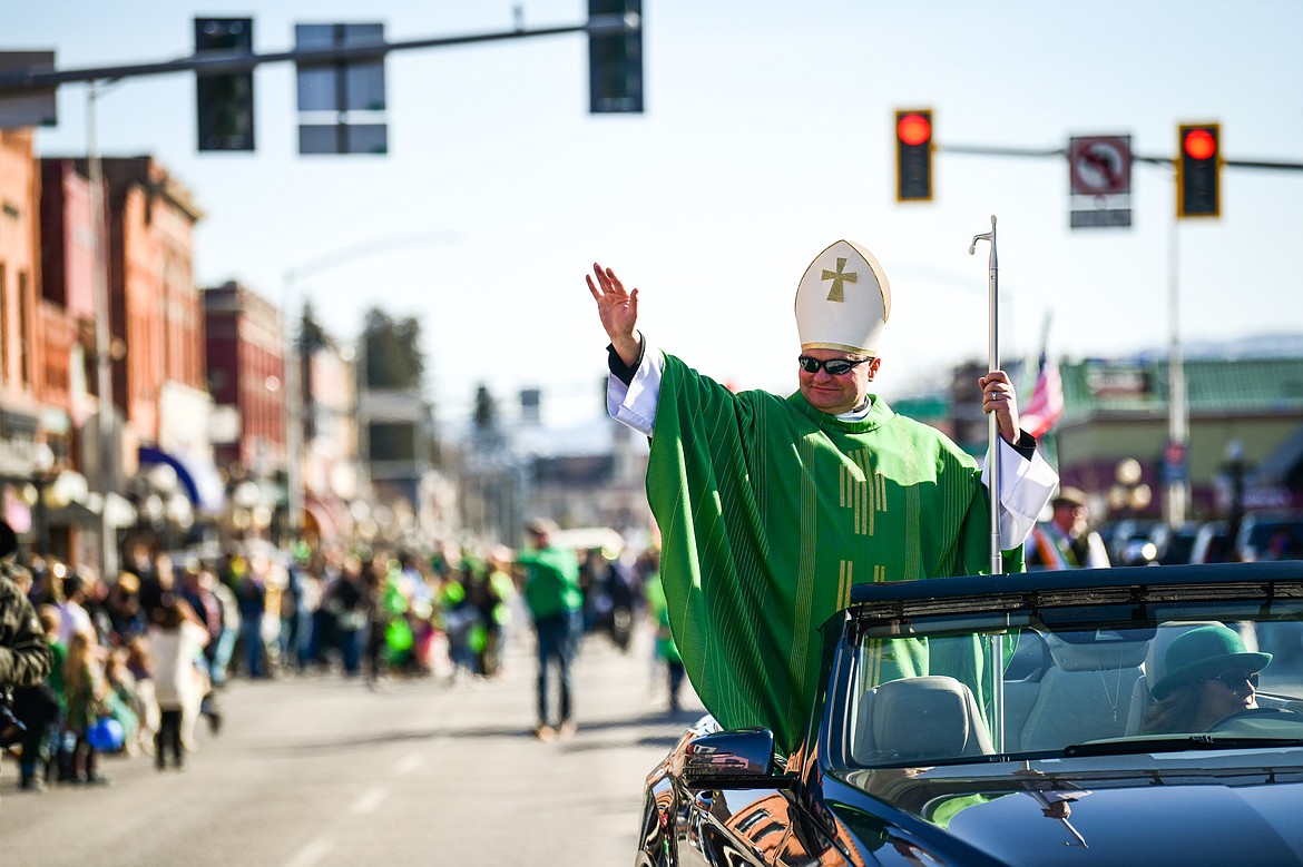 Father Stanislaw Rog, from St. Matthew's Catholic Church, rides in a vehicle during the St. Patrick's Day Parade in Kalispell on Friday, March 17. (Casey Kreider/Daily Inter Lake)